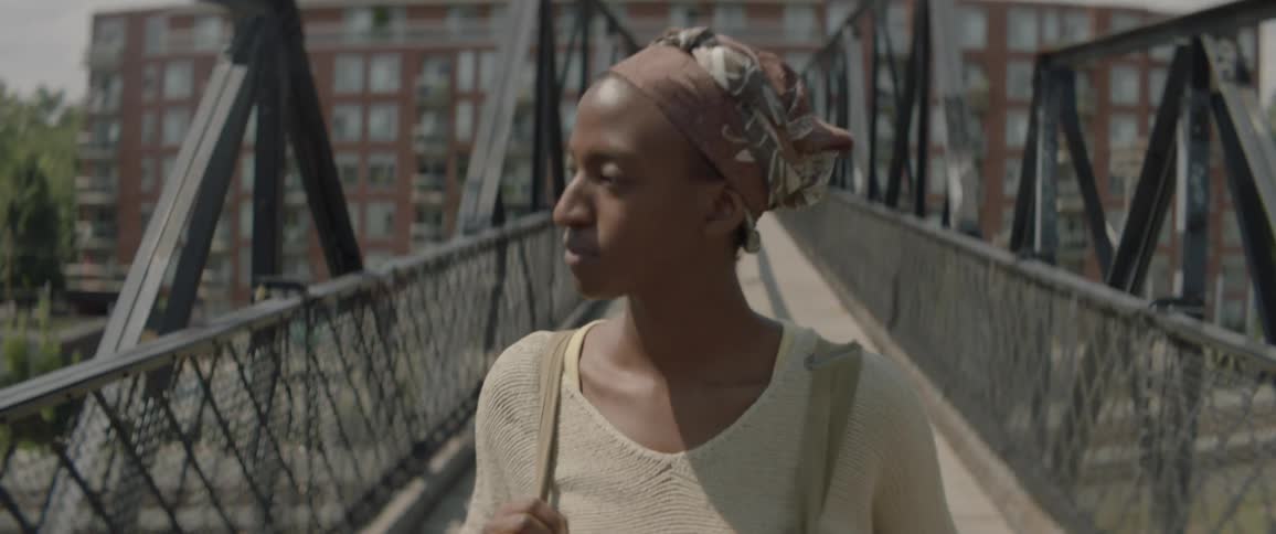 A person walks across a bridge during the day