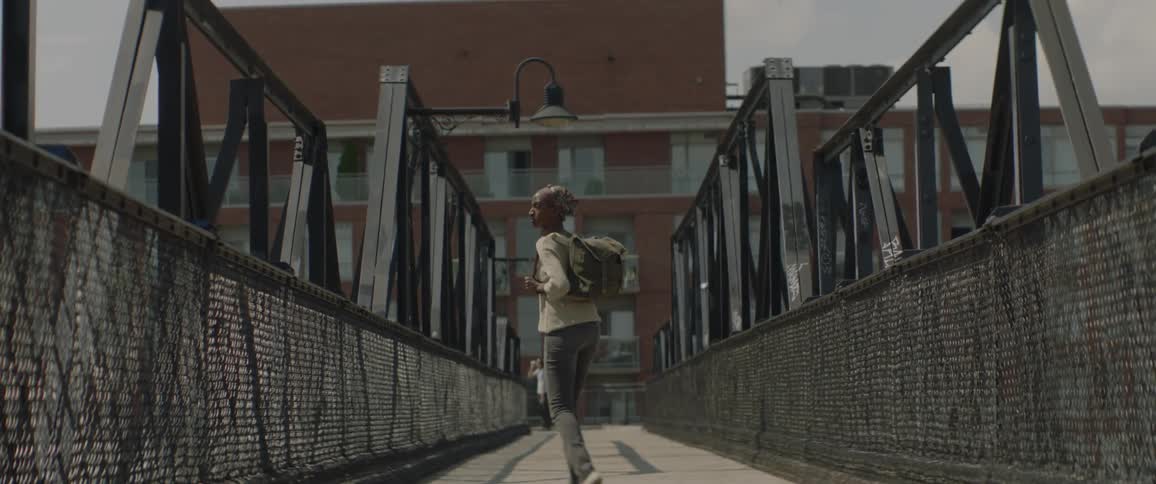 A woman is crossing on the overpass