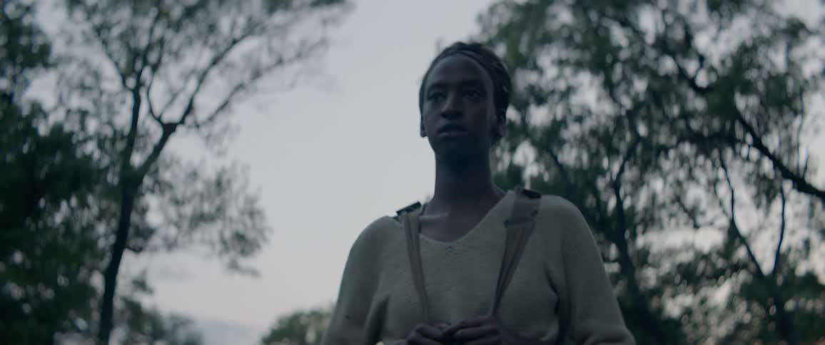 A woman walks outside carrying a backpack