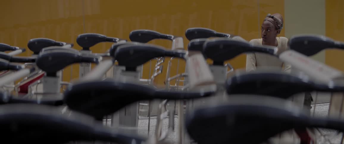 A person sitting near a line of shopping carts