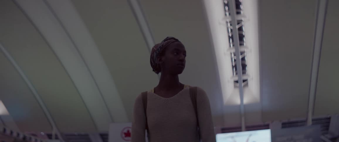 A woman with a backpack looks confused and overwhelmed in an airport