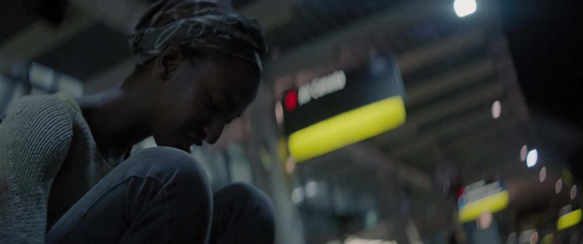 A girl sits on the curb near a terminal and cries
