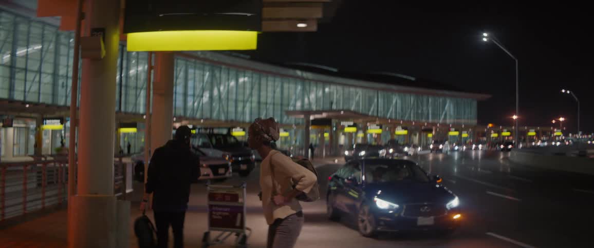 A woman panhandles outside of an airport