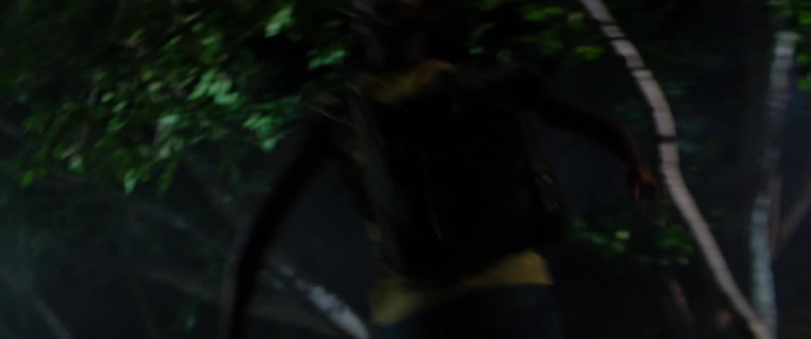 A person runs through the forest at night