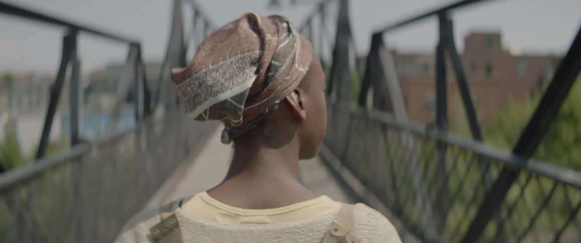 Woman walks across a city bridge
