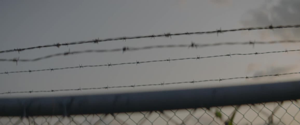 Barbwire lined the top of a chain link fence