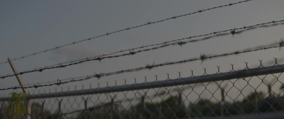 Barbwire is covering the top of a fence