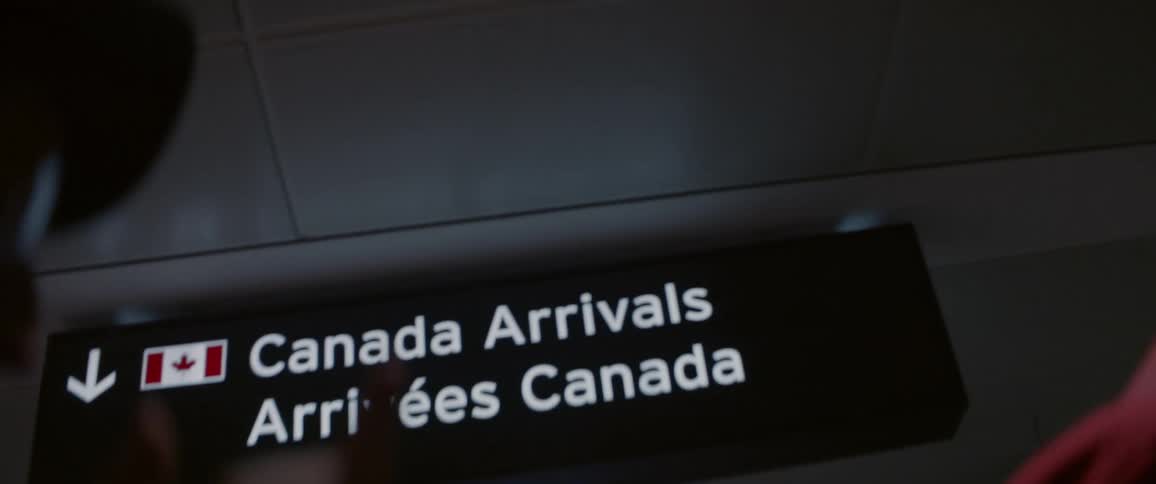 A sign hangs from an airport ceiling