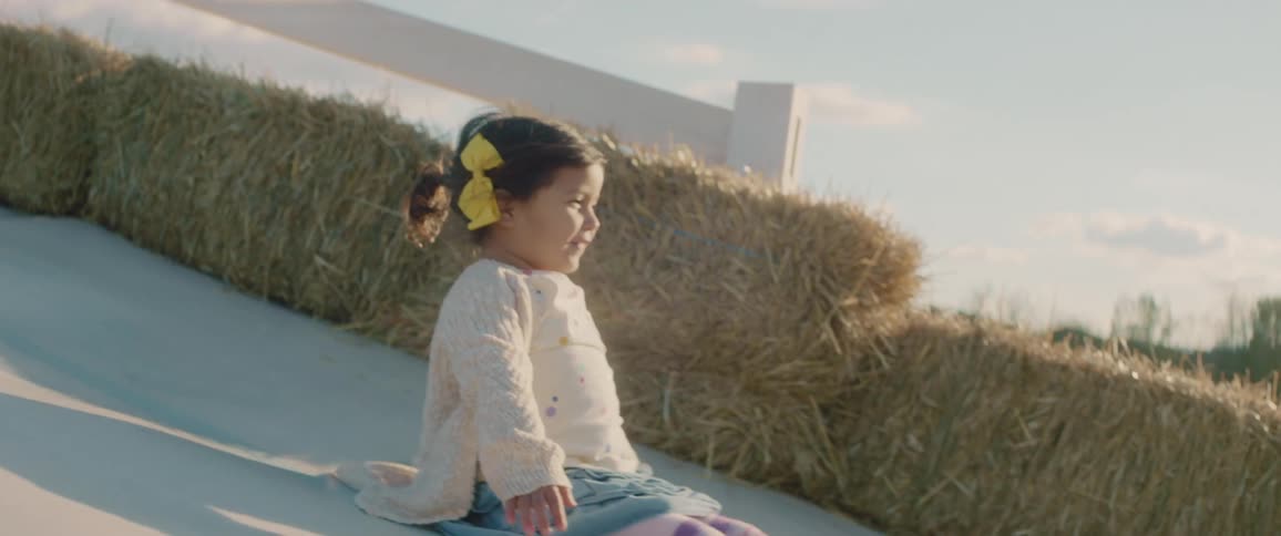 A little girl sliding down a ramp