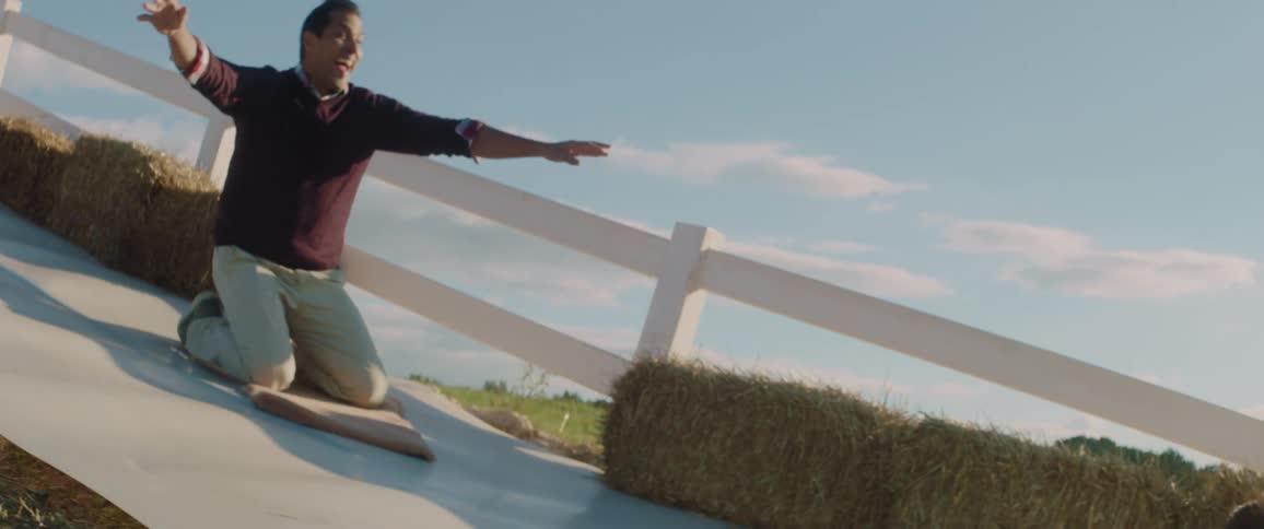 A family goes down a slide on a farm