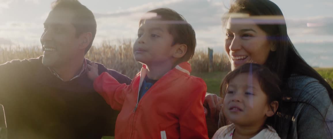 A family are sitting together and being pulled by a tractor
