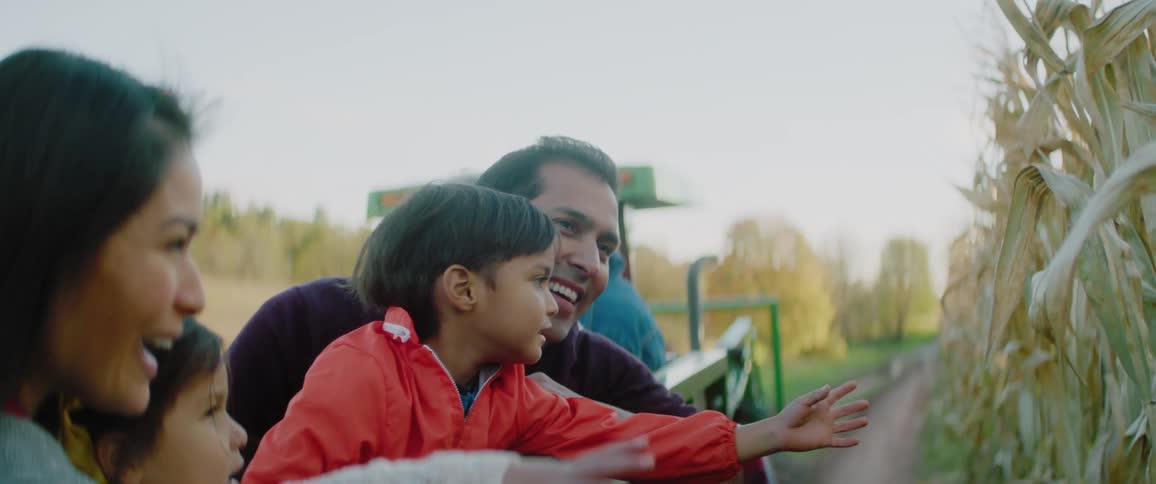 A family laughs as the children reach over the sides on a hayride