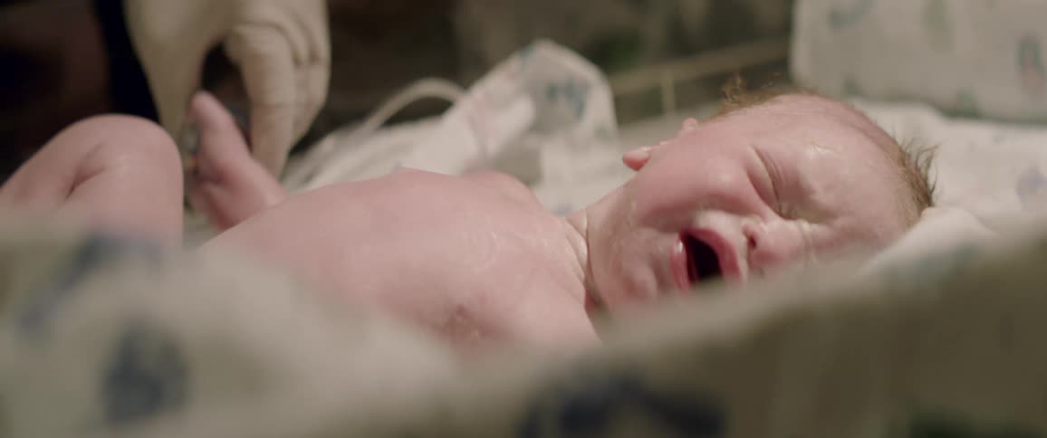 A crying baby is examined by a doctor