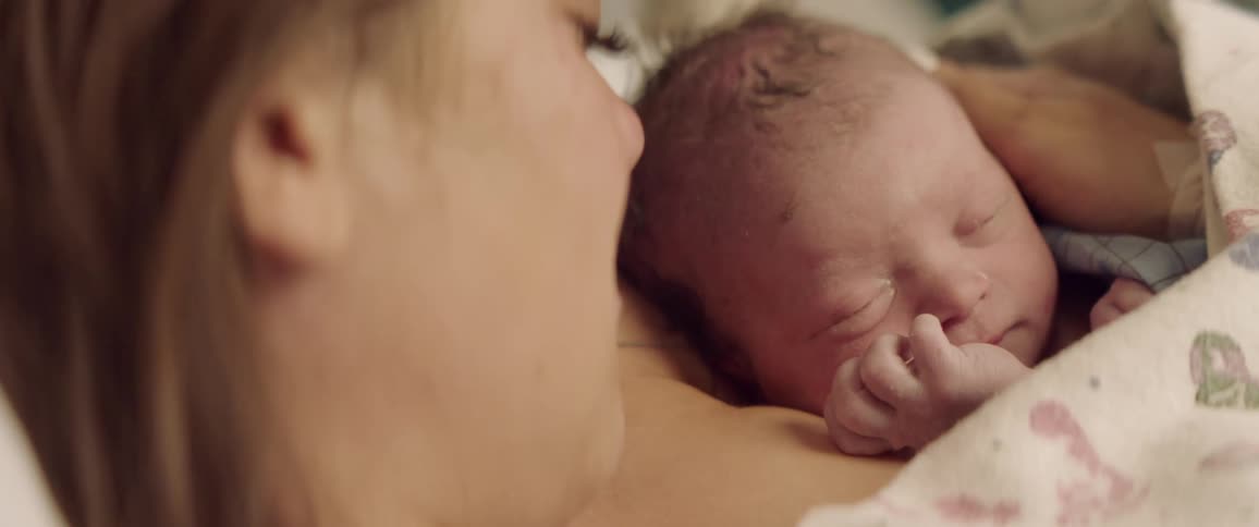 A mother holds a newborn baby to her chest