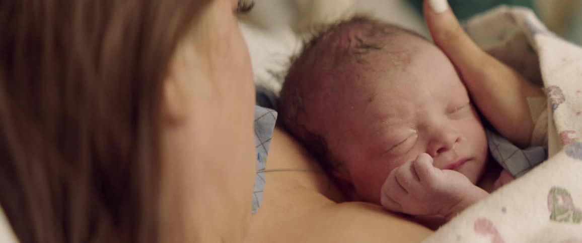 A mother holds a newborn baby to her chest