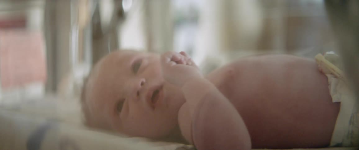 A newborn lies in a bassinet