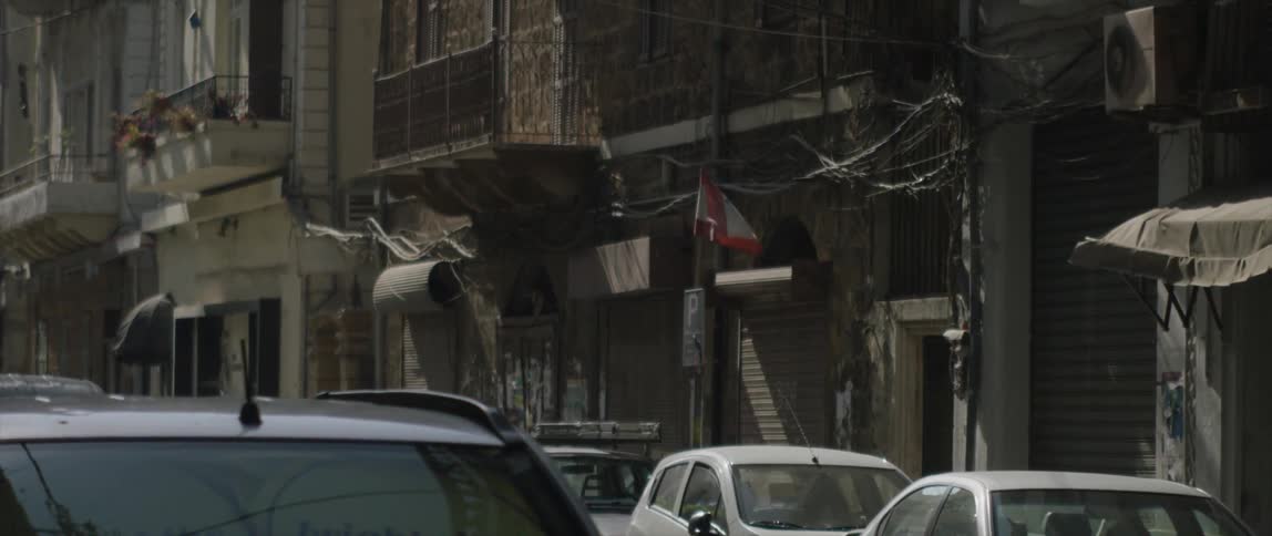 A flag flapping in the breeze on an urban street