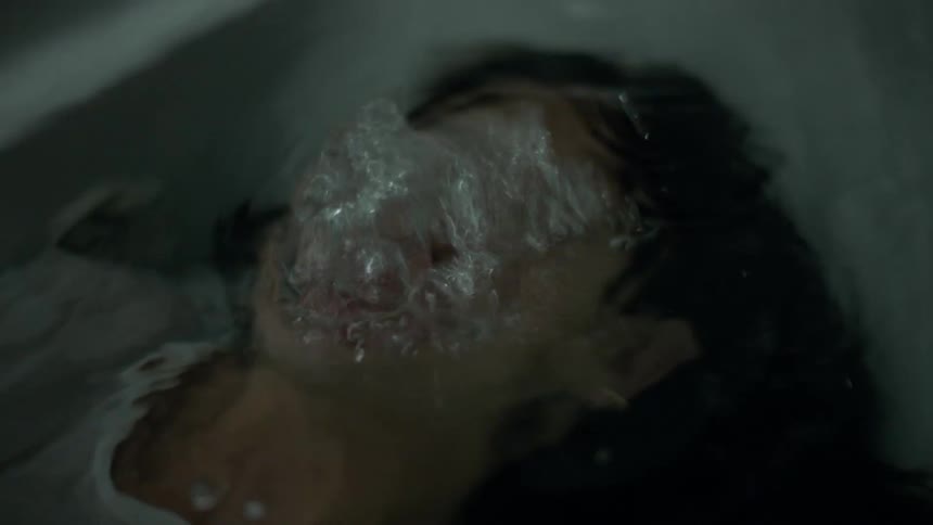A woman exhales underwater in a bathtub