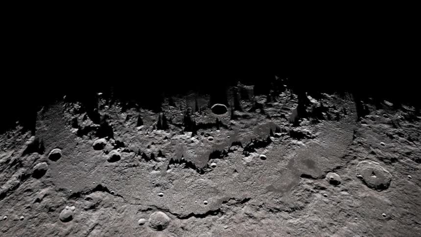 From high above the surface of the moon is illuminated which casts long shadows across its craters and mountains