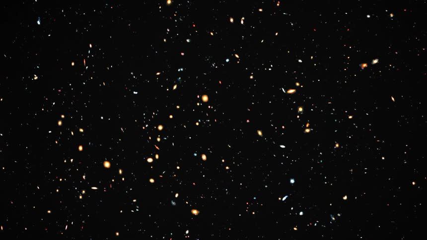 Lights glow and particles float by against black space