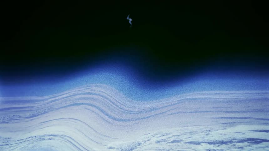 The planet of earth can be seen from outer space but its cloud covered atmosphere is severely warped by a large wave of distortion