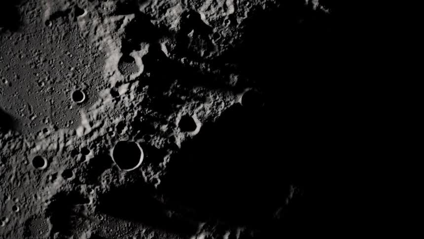 Lit areas of pitted lunar surface contrast with dark shadowy areas