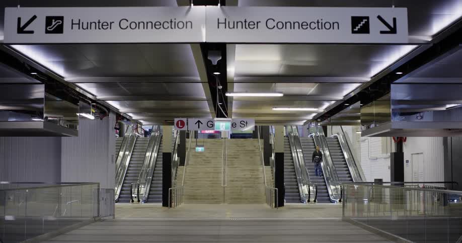 A person climbs down the stairs into the train station