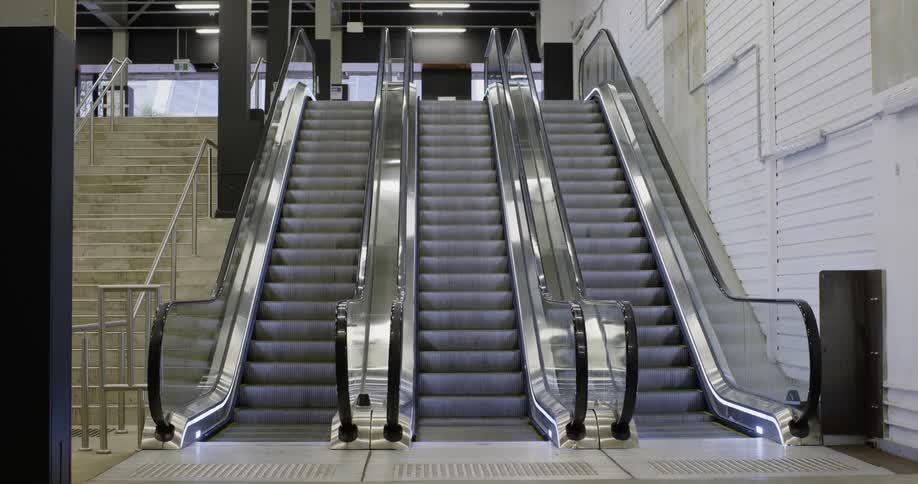 Empty escalators steps move down next to empty staircase