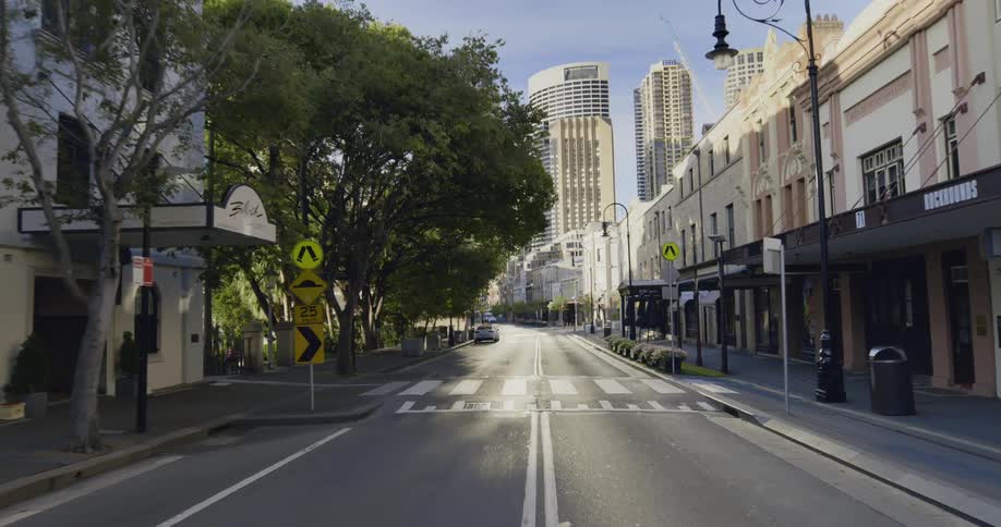 A relatively empty city street in a metropolis during the day