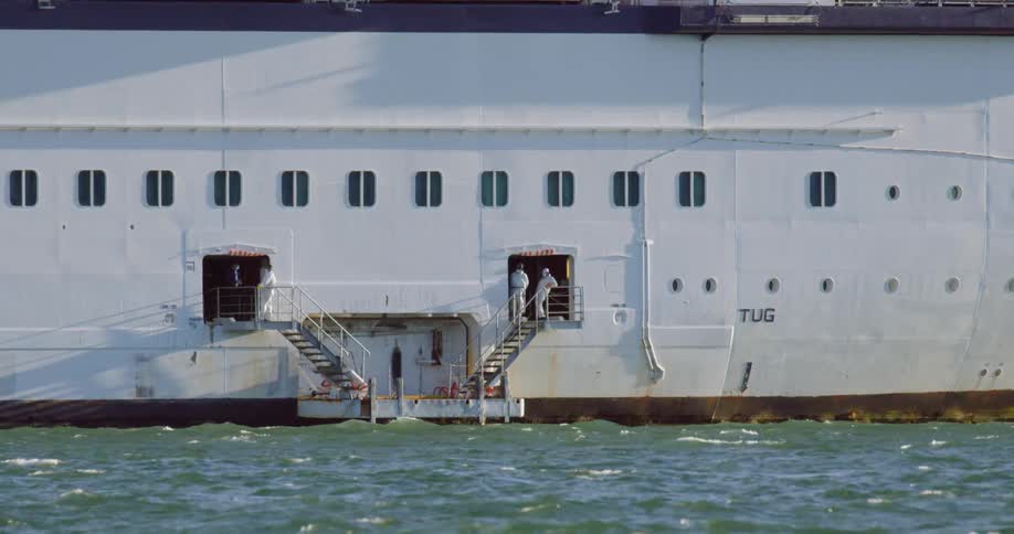 Sailors stand on the steps of the boat