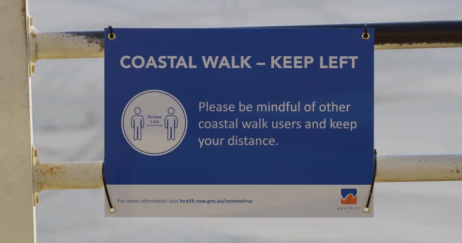 A woman walks past the sign