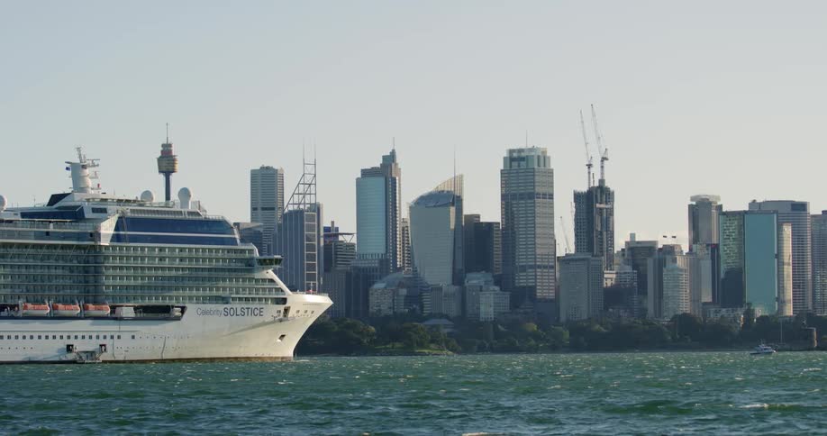 Large multideck cruise ship moves floats near city downtown