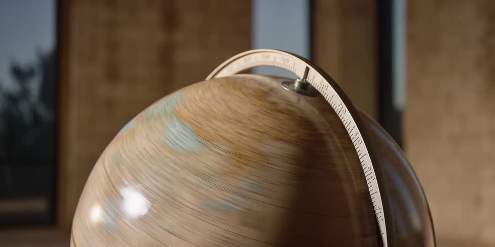 An earth globe map is spinning very quickly before it loses its momentum