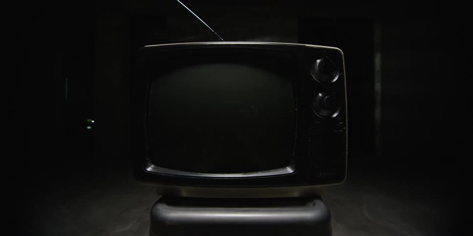 In a dark room a television set spontaneously turns on and displays only static on its screen