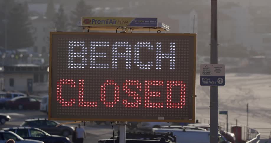 A sign by the parking lot reads beach closed