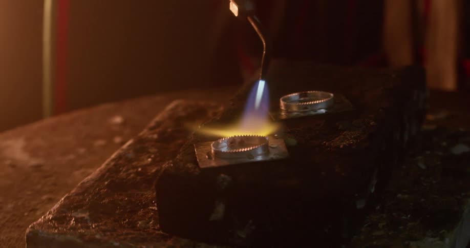A piece of metal is torched on a rotating stone table