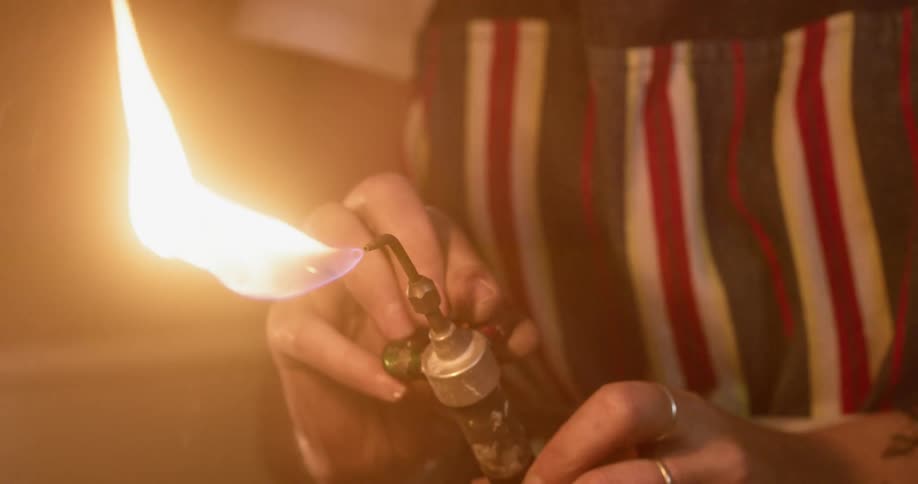 A person holding a blowtorch with fire and smoke