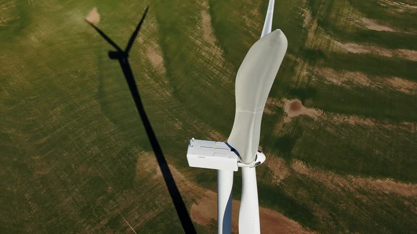 An aerial view of a wind turbine in a rural field
