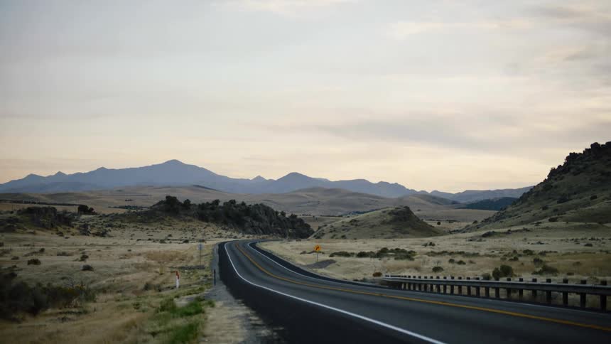 View of a winding highway through hills at dusk