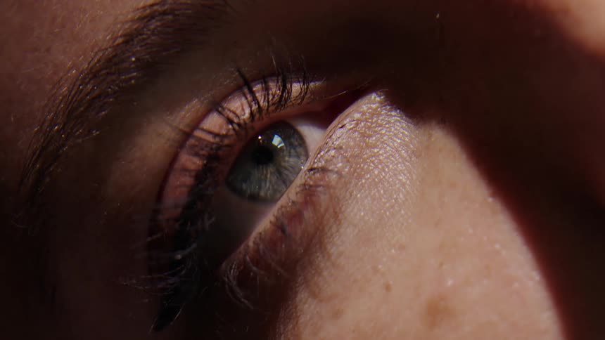 A woman opens her eyes to the morning sunlight
