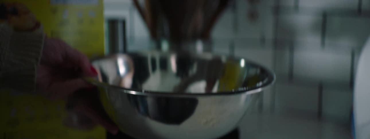 A person puts some flour in the bowl
