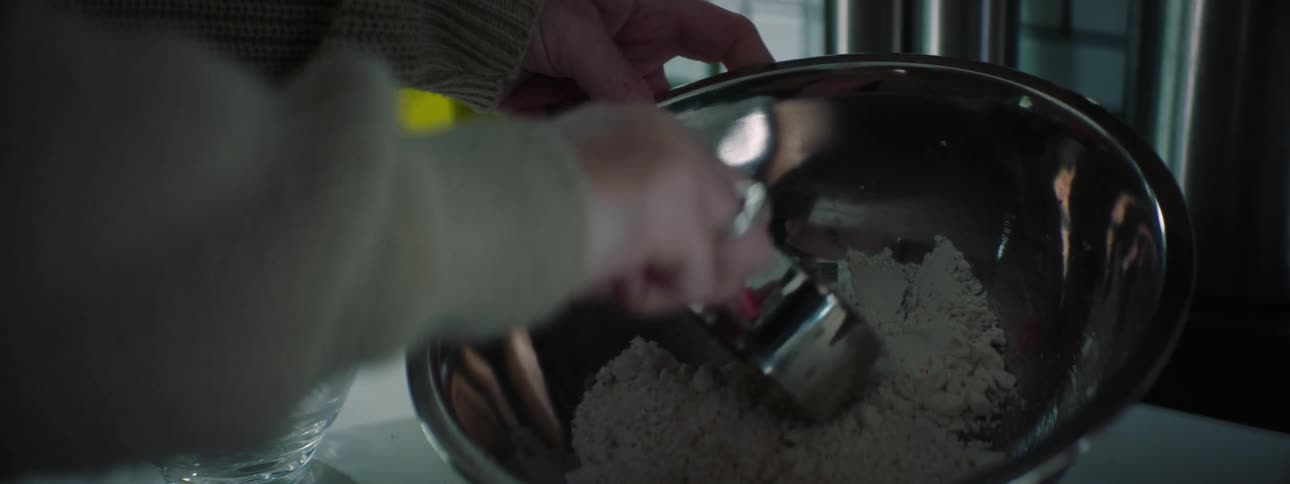 A person is mixing flour in a bowl