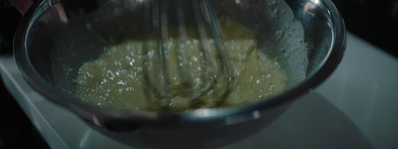 A woman is mixing with a whisk