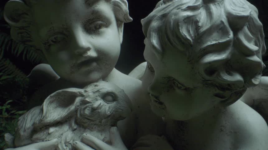 A sculpture of a pair of winged children holding a rabbit