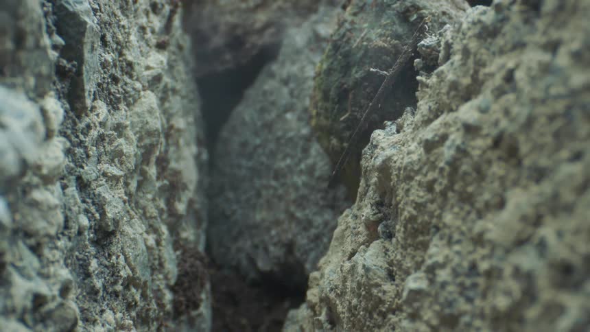 The darkness flows through the crevice in the rocks
