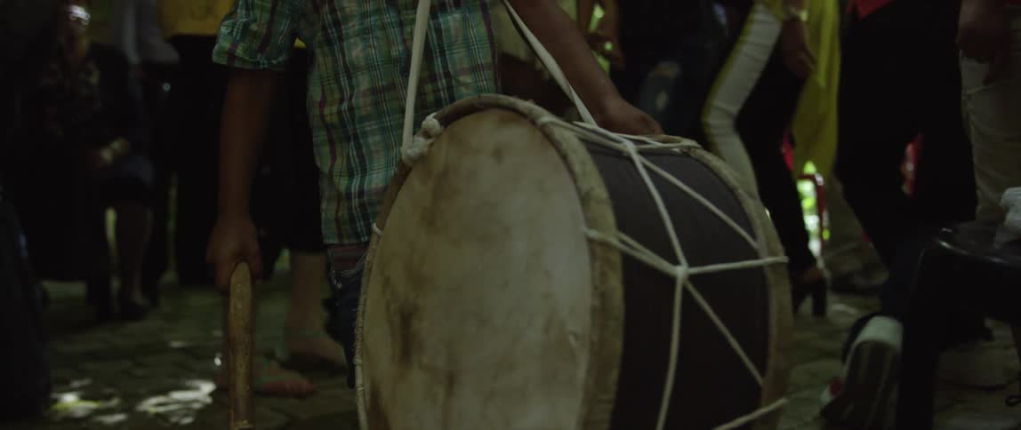 A man is beating a drum at a party