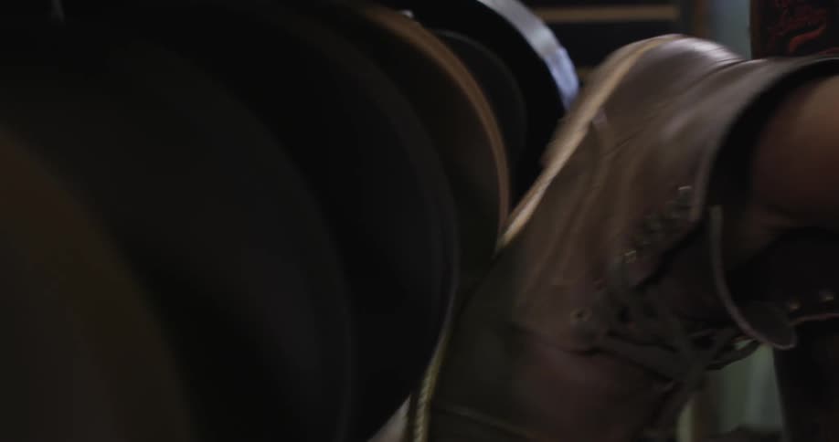 A person is working polishing shoes with a machine