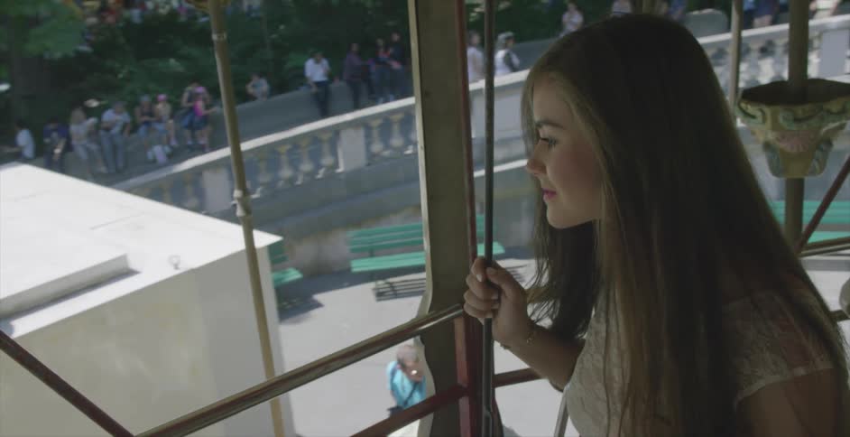 A woman is in a ride looking out a window smiling