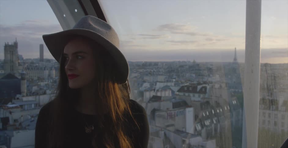 A woman stands on a platform overlooking a city