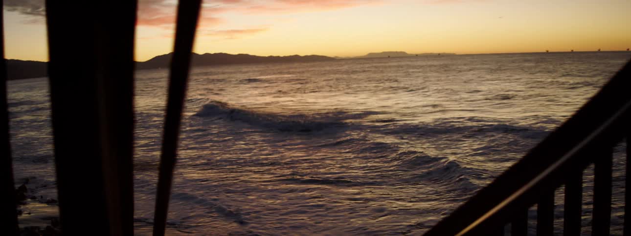 Ocean waves are moving towards the coast at dusk